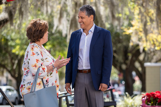 Two individuals standing outside having a conversation. 