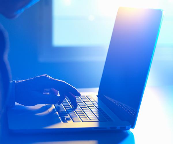 A person is typing on an open laptop.