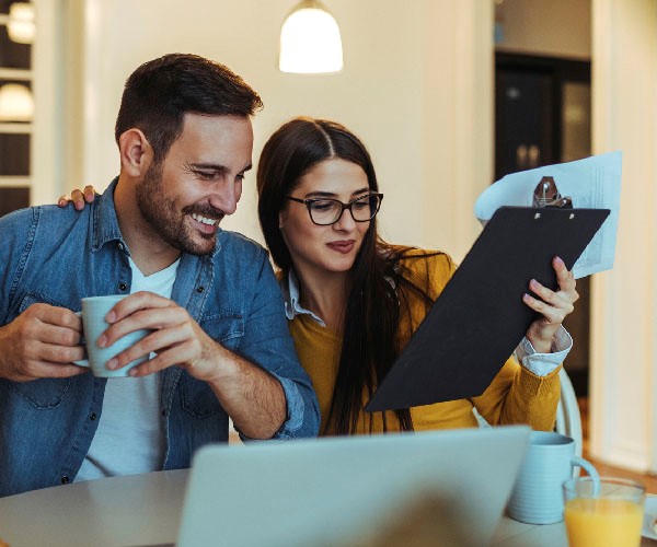 A couple looking over a document on a clipboard. 