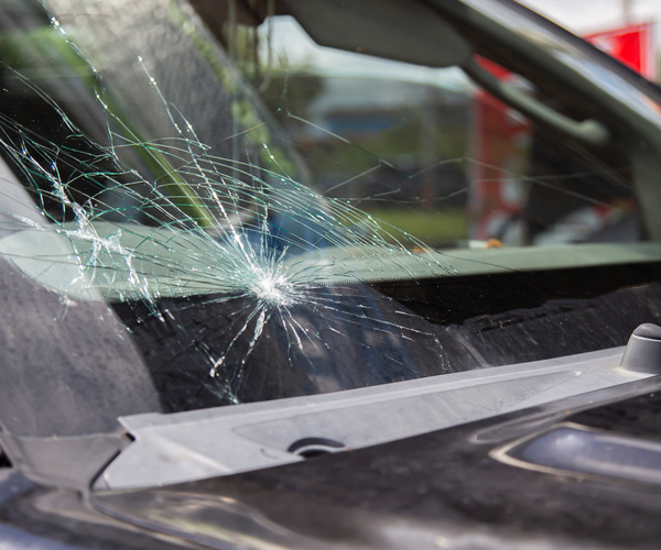 Car windshield with a large crack in the middle.