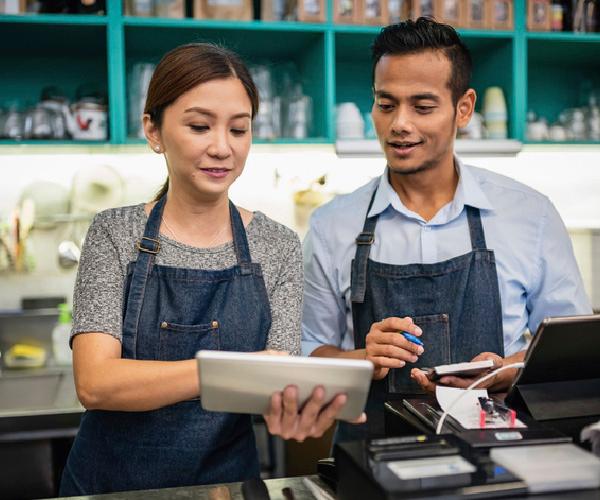 A person is holding a tablet showing it to another person.