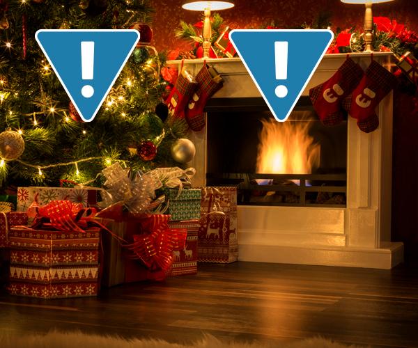 Two exclamation points inside blue upside down triangles are in front of a decorated tree that is next to a lit fireplace.