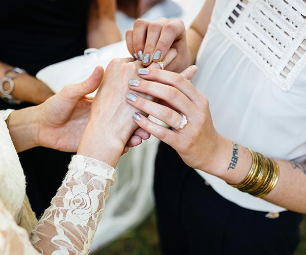 An aerial, zoomed in view of a couple the moment they exchange rings at their wedding ceremony.