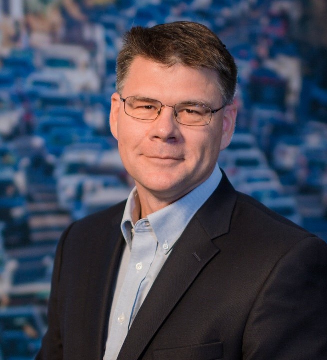 Man with glasses wearing a blazer and dress shirt. 