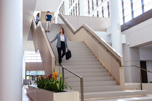 An individual holding a hand rail while walking down a stair case.	